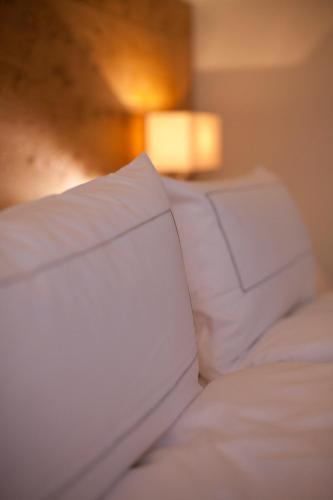 a bed with white sheets and pillows in a room at Gasthof Zufriedenheit in Naumburg
