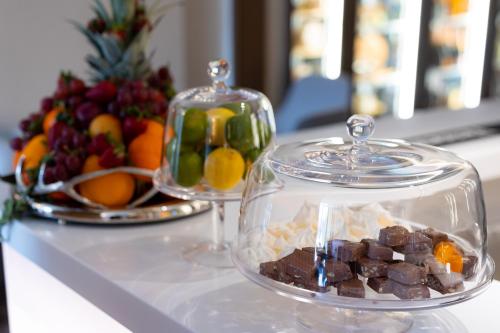 a glass dish with chocolate and a bowl of fruit at Hotel Belmont & Spa in Sinaia
