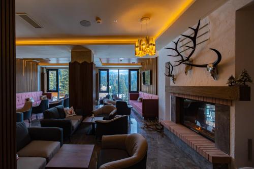 a living room with couches and a fireplace at Hotel Belmont & Spa in Sinaia