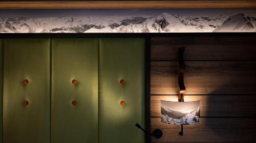 a light on a wooden wall with a snow covered mountain at Hotel Belmont & Spa in Sinaia