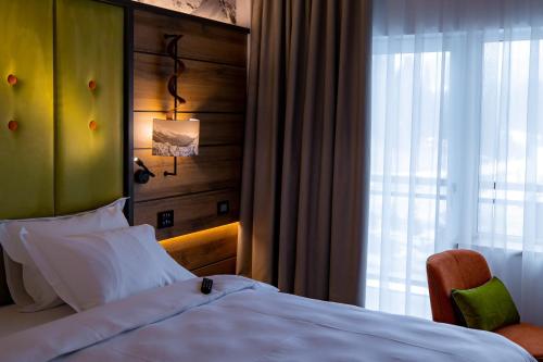 a hotel room with a bed and a window at Hotel Belmont & Spa in Sinaia