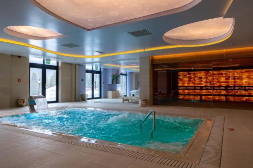 a large swimming pool in a hotel room with at Hotel Belmont & Spa in Sinaia