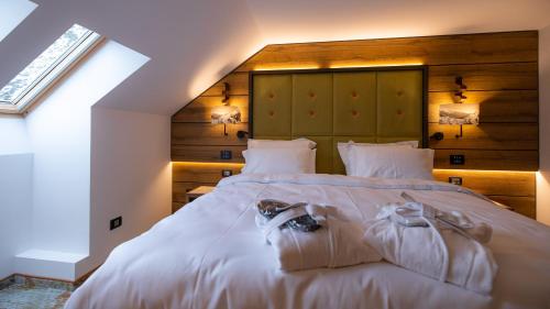 a bedroom with a large white bed with two towels on it at Hotel Belmont & Spa in Sinaia