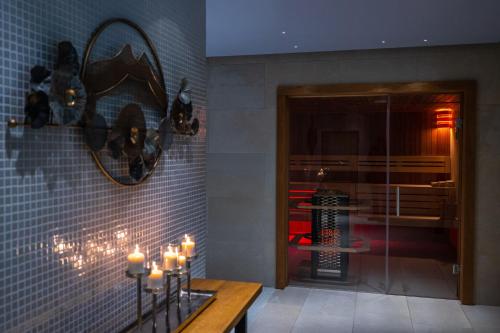 a room with a table with candles and a mirror at Hotel Belmont & Spa in Sinaia