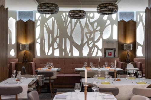 a dining room with white tables and chairs at Hotel Belmont & Spa in Sinaia