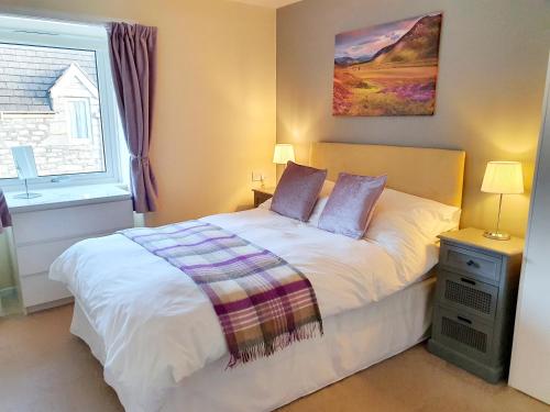 um quarto com uma cama e uma janela em Elmwood House em Pitlochry
