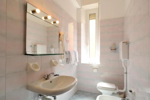 a bathroom with a sink and a toilet and a mirror at Affittacamere Giannina in Alassio