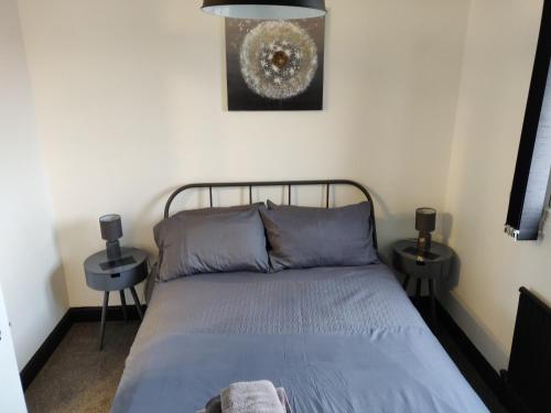 a bedroom with a bed and two night stands at Riverside Park Penthouse Apartment In St Neots in Saint Neots