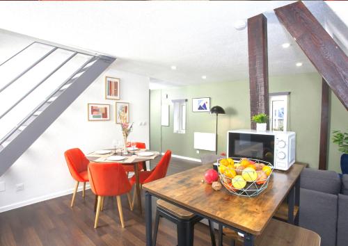 un soggiorno con un tavolo su cui è appoggiata una ciotola di frutta di Duplex - Le Cosy - Hyper Centre a Haguenau