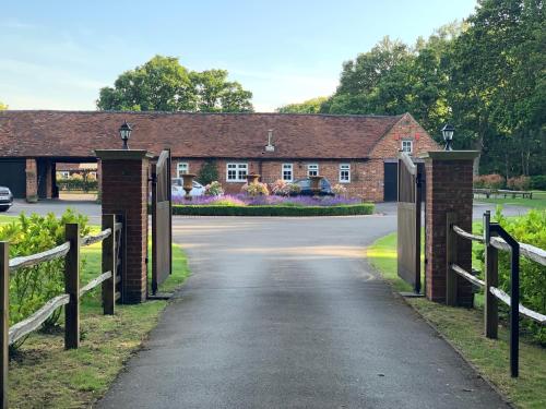 a driveway leading to a house with a gate at Whitmoor Farm & Spa in Guildford