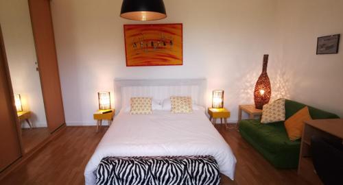 sypialnia z łóżkiem i zieloną kanapą w obiekcie La Villa des Coteaux w mieście Pomport