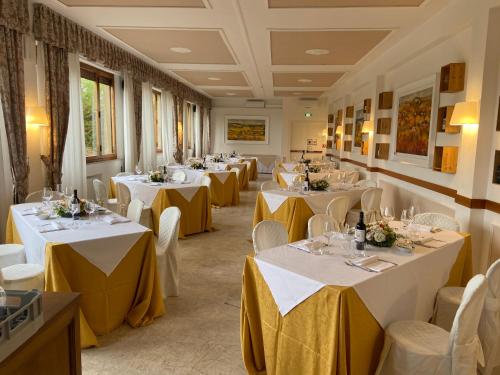 una fila de mesas en un restaurante con mantelería amarilla en Certosa di Pontignano Residenza d'Epoca en Ponte A Bozzone