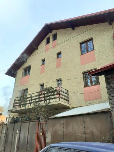 an apartment building with a balcony and a car parked in front at CASA RYANA SINAIA in Sinaia