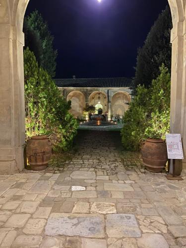 a stone walkway leading to a building at night at Certosa di Pontignano Residenza d'Epoca - Place of Charme in Ponte A Bozzone