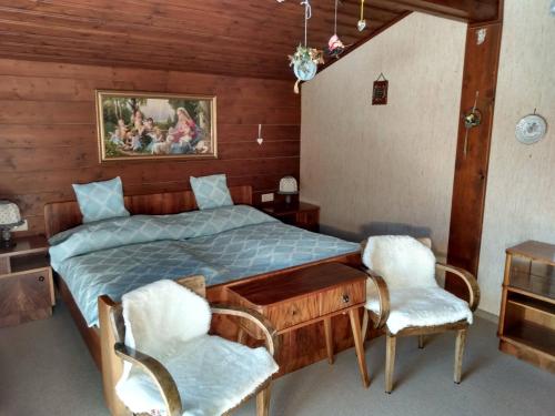 a bedroom with a bed with a desk and two chairs at Almidylle Kathrin in Strobl