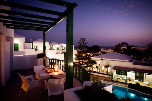 a balcony with a table and chairs at night at Apartamentos El Guarapo in Costa Teguise