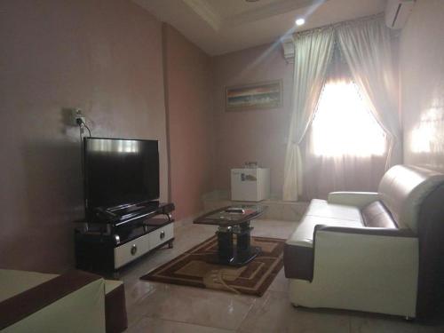 a living room with a couch and a tv at Nera Hotels in Jabi