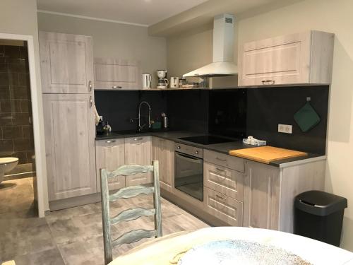 uma cozinha com armários brancos e uma cadeira em apartment (80m2) 3 bedrooms (up to 8 pers) town centre Menton em Menton