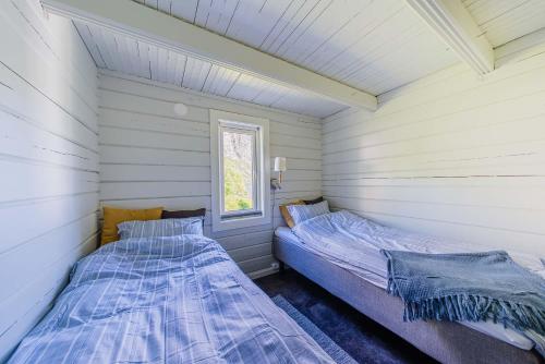 two beds in a room with white walls at Senja Fjordcamp in Torsken