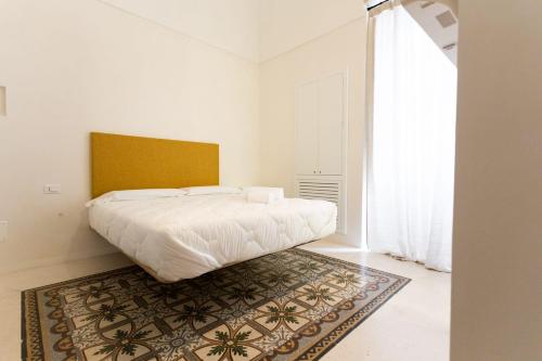 a bedroom with a bed and a rug on the floor at Viasarnelli72 in Polignano a Mare