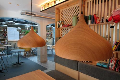 a restaurant with wooden pendant lights hanging from the ceiling at H Complutum in Alcalá de Henares