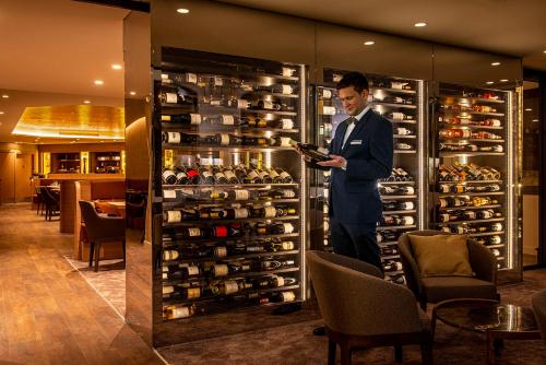 a man in a suit standing in front of a wine cellar at Radisson Blu Hotel, Rouen Centre in Rouen