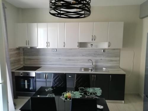 a kitchen with white cabinets and a sink and a counter at Haus Viktoria 3 in Limenas