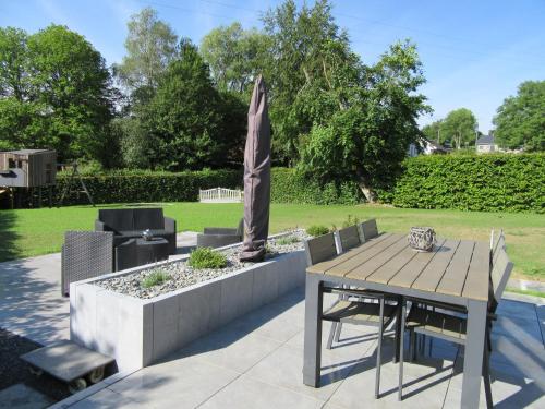 a patio with a table and chairs and an umbrella at Gite du Circuit in Stavelot