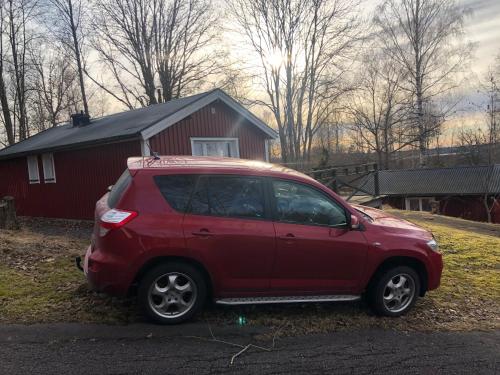 a red car parked in front of a red house at Holiday House with beautiful scenery near Göta Kanal in Undenäs