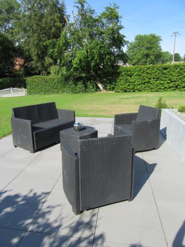 a group of chairs and tables on a patio at Gite du Circuit in Stavelot