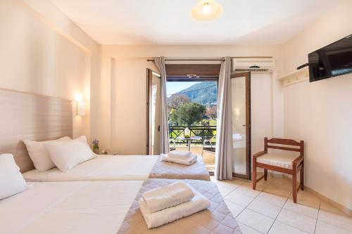 een slaapkamer met een bed, een televisie en een stoel bij Lemon Tree Corfu Apartments by Konnect in Ýpsos