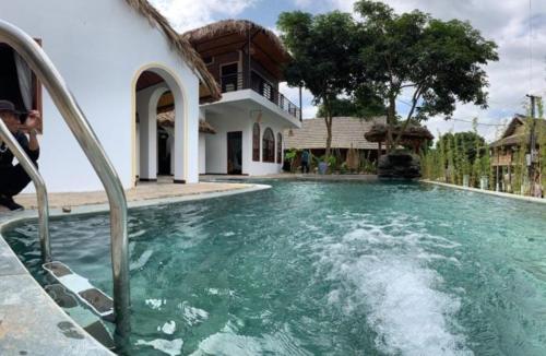 a swimming pool in front of a house at Mai Chau Rustic Home in Mai Chau