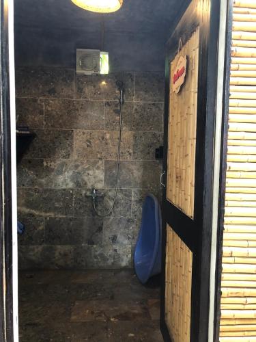 a bathroom with a shower with a blue chair in it at Mai Chau Rustic Home in Mai Chau