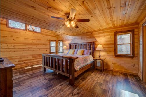 a log cabin bedroom with a bed and a ceiling fan at The Hideaway in Blue Ridge