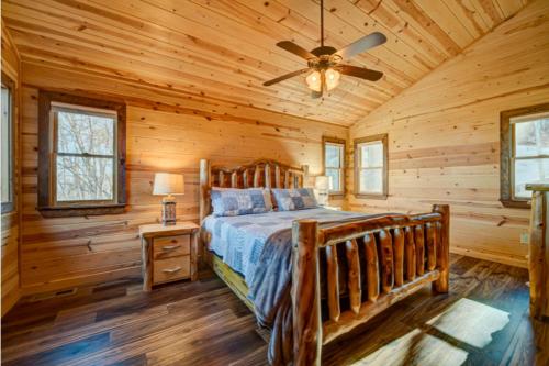a log cabin bedroom with a bed and a ceiling fan at The Hideaway in Blue Ridge