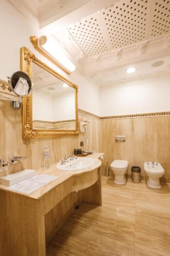 a bathroom with a sink and a mirror and a toilet at Axelhof Boutique Hotel in Dnipro