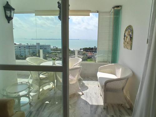 a balcony with a table and chairs and a view of the ocean at Apartamento Sea Views Las Redes in El Puerto de Santa María