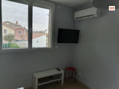 a room with a tv and a stool and a chair at Immoappart in Albi