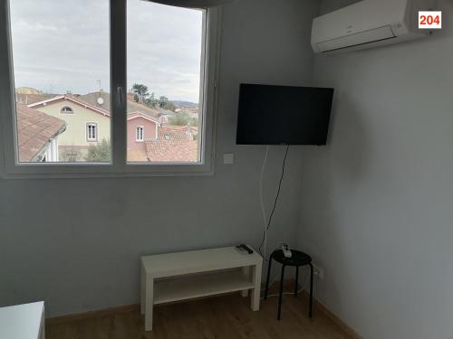 a room with a tv and a table and a window at Immoappart in Albi