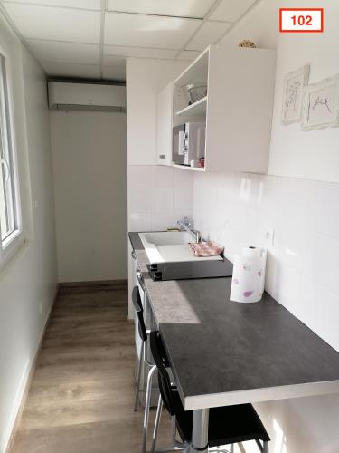 a kitchen with a sink and a table with chairs at Immoappart in Albi