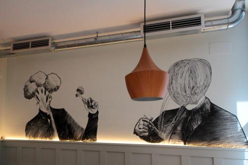 a wall with two drawings of people on it at H Complutum in Alcalá de Henares