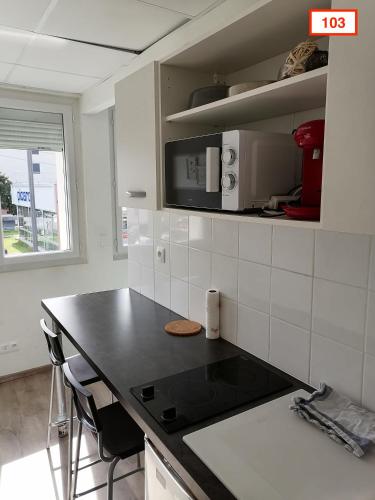 a kitchen with a black counter top and a stove at Immoappart in Albi