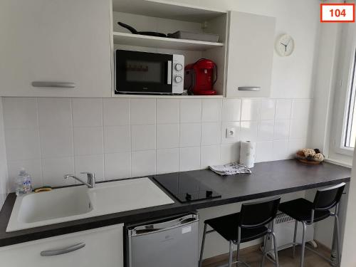 a kitchen with a counter with a sink and a microwave at Immoappart in Albi