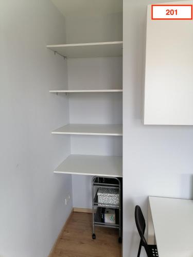 a room with white shelves and a table at Immoappart in Albi