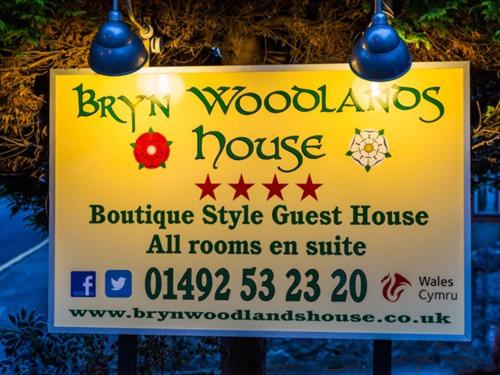 a sign for a bryan woodlands house on a street at Bryn Woodlands House in Colwyn Bay