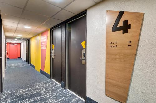 a hallway with a door in an office building at B&B HOTEL Orly Rungis Aéroport 2 étoiles in Rungis