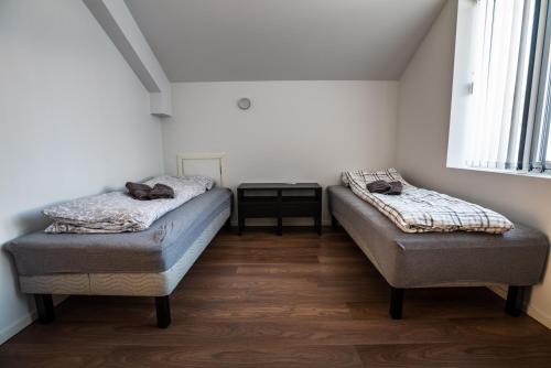 two twin beds in a room with a window at Penthouse Leilighet TorskenSenteret in Torsken