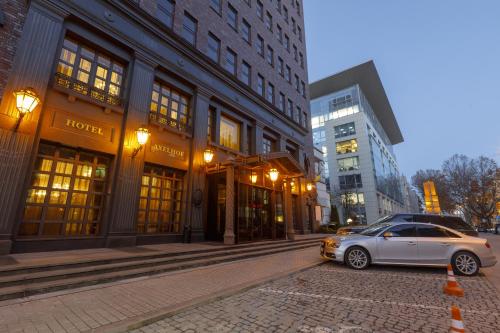 a car parked on a street in front of buildings at Axelhof Boutique Hotel in Dnipro