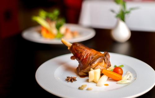 a plate of food with meat and vegetables on a table at Hotel Borj Rabat - A member of Barceló Hotel Group in Rabat