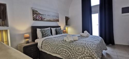 a bedroom with a bed with two stuffed animals on it at Alexandra's Home in Fira